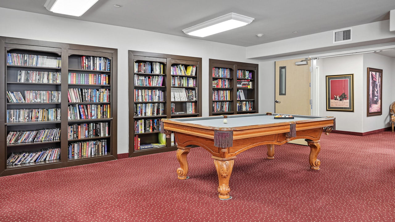 The library at Scholl Canyon Estates with shelves of books and comfortable seating