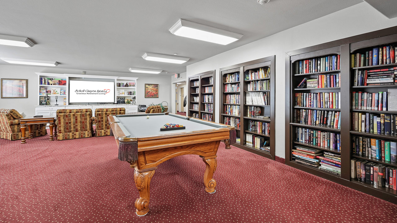 The library at Scholl Canyon Estates with shelves of books and comfortable seating