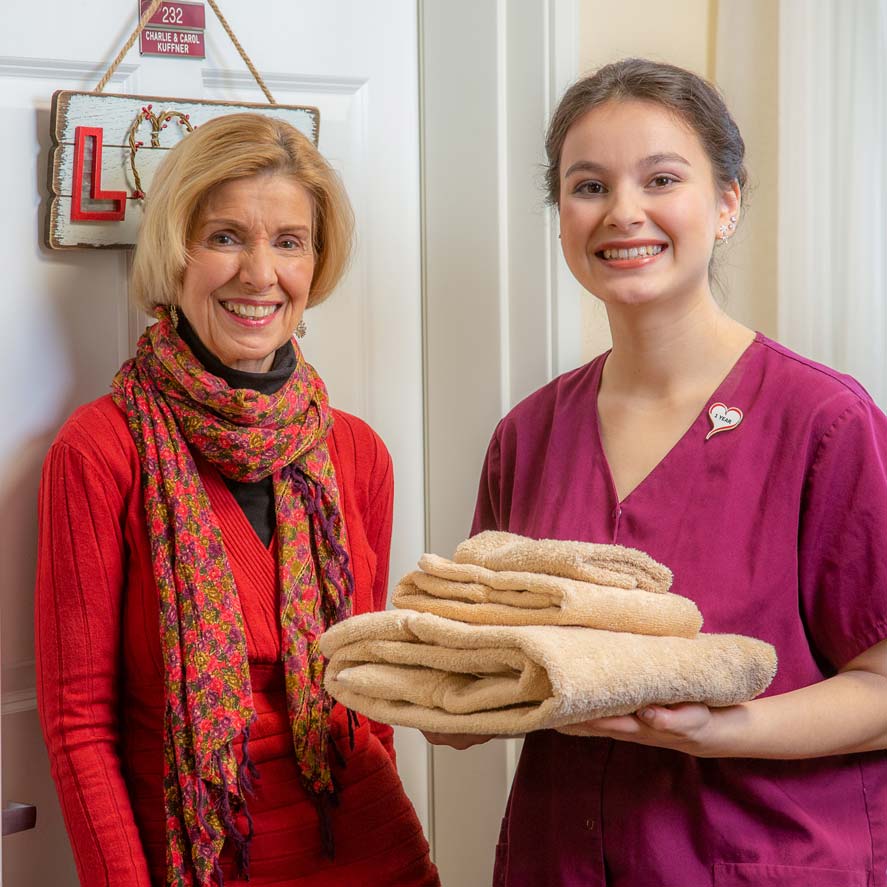 A team member delivering fresh linens to a resident at Scholl Canyon Estates